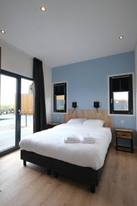 KottenHofparken Wiltershaar - groepsaccommodatie met privé wellness的一间大卧室,配有一张白色的大床和窗户