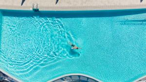 波多黎各凯莱宫阿马多雷斯塔拉索酒店的在大型游泳池游泳的人
