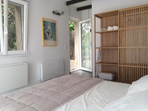 尼姆Chambre indépendante avec terrasse privée et piscine的一间卧室设有一张大床和一个窗户。
