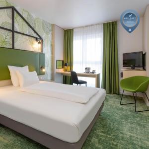 汉诺威汉诺威米特美居酒店的酒店客房设有一张大床和一张书桌。