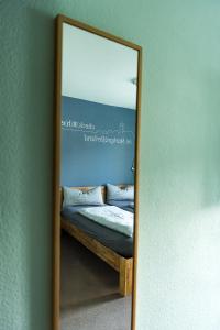 莱茵河畔的纳沙泰尔Hotel Check-Rhein - Self Check-in的卧室内床的镜子反射