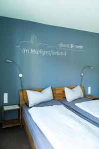 莱茵河畔的纳沙泰尔Hotel Check-Rhein - Self Check-in的一间卧室设有两张床和蓝色的墙壁
