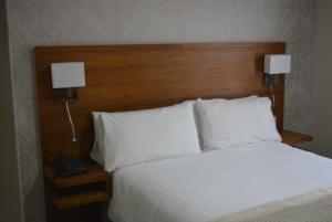 Stallingborough斯塔灵波勒农庄酒店的一间卧室配有一张带白色枕头的床和两盏灯。