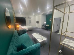 阿奴古MUSE Boutique Hotel的客厅配有绿色沙发和床。