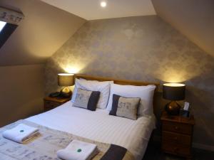 Millton of ClovaGlen Clova Hotel & Luxury Lodges的一间卧室配有一张带两个枕头的床