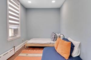费城Stylish Rowhome-Fishtown-Near Shops的一间卧室设有蓝色的沙发和窗户。