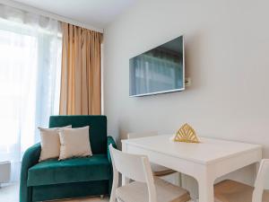 斯维诺乌伊希切VacationClub ApartPark Lividus Apartament 137的客厅配有白色桌子和绿色椅子