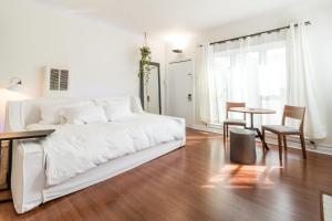 洛杉矶Sunny Boho Chic West Hollywood Flat!的白色的卧室配有白色的床和一张桌子