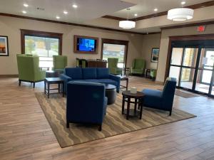 西门罗Comfort Suites West Monroe near Ike Hamilton Expo Center的一间配备有蓝色沙发和椅子的等候室