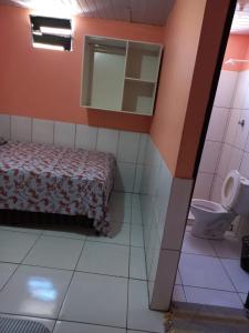 特雷西纳Pousada Kaka的一间卧室配有一张床、镜子和卫生间