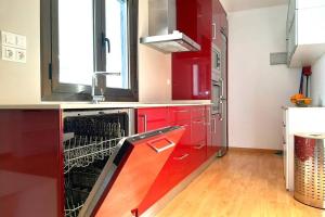 蒙宗Ático en Monzón的一间带红色橱柜和洗碗机的厨房