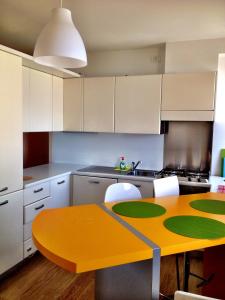 弗留利地区奇维达莱Casa Romea的厨房配有黄色桌子和白色橱柜