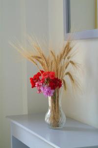 皮拉Sunbay Apartments的花瓶,桌子上装有红色和紫色的花朵