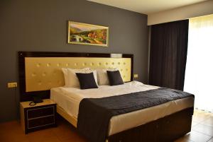 锡德Nora Suit Hotel的一间卧室设有一张大床和一个窗户。