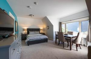 尼尔逊Cloudside Hotel的卧室配有一张床和一张桌子及椅子