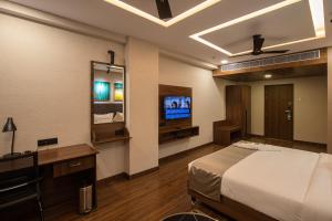 哥印拜陀Windstone Residency的一间卧室配有一张床和一台电视