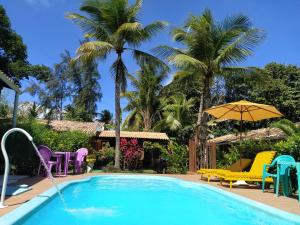 因巴塞坎特德因巴塞旅馆的一个带椅子和遮阳伞的游泳池,并种植了棕榈树
