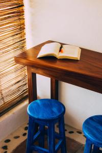 CuatunalcoHotel el Risco的一张木桌上的开放式书,上面有两把蓝色凳子