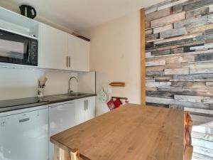 莱斯奥琉斯Appartement Méribel, 2 pièces, 4 personnes - FR-1-182-237的厨房配有石墙前的木桌