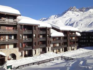 莱斯奥琉斯Appartement Méribel, 2 pièces, 4 personnes - FR-1-182-237的一座被雪覆盖的建筑,背景是群山