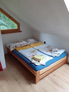 KníniceKyprův mlýn的一间卧室配有一张带蓝色床单的床和一扇窗户。