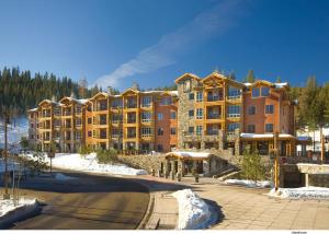 特拉基Hyatt Vacation Club at Northstar Lodge的一座大公寓楼,位于雪地里,街道上