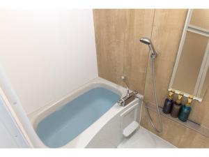宜野湾市エンズ　マリーナ　イン　マシキ　コンド・ホテルズ的浴室设有浴缸和淋浴。