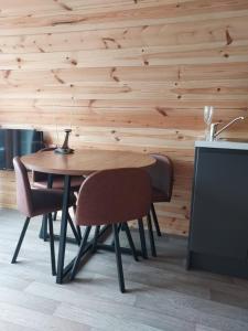 AphortArranmore Glamping的木墙客房内的一张木桌和椅子