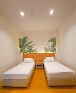 AbepuraFront One Green Boutique Hotel Abepura的白色墙壁客房的两张床