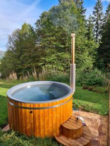 费尔德伯格Luxus-Ferienhaus Blockhaus Chalet Nr 2 Toplage am Feldberg mit Sauna, Outdoor-Hottub, Kamin auf 1300m üM的庭院内的木制热水浴缸,设有木甲板