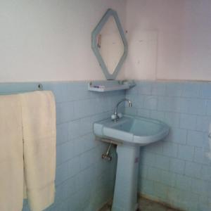 TīshForeigner Tourist Inn的浴室设有水槽和墙上的镜子
