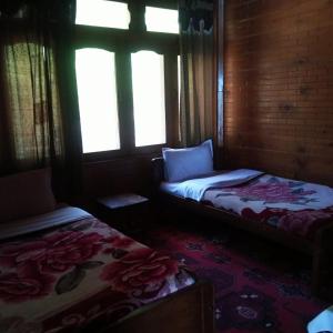 TīshForeigner Tourist Inn的带两张床和两个窗户的房间