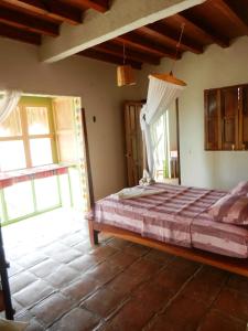 马祖特Altamira Mazunte的一间设有床铺的卧室,位于带窗户的房间内
