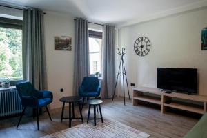 ŽeleznikiApartma Ajda的客厅配有2把蓝色椅子和电视