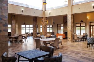 奈瓦沙Elmer Resort & Spa Naivasha的餐厅设有桌椅和窗户。
