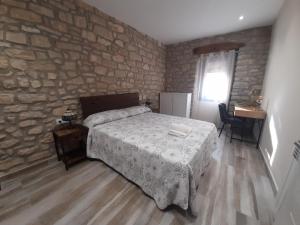 瓦尔博纳-德拉蒙Pati de Cal Espardenyer的一间卧室设有一张床和石墙