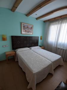 卡索拉卡索拉之门酒店的一间设有一张大床的卧室,位于带蓝色墙壁的房间