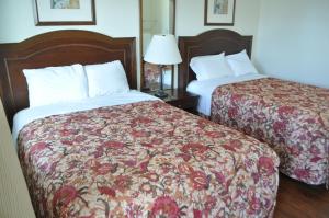 大洋城浪花汽车旅馆的酒店客房,设有两张床和一盏灯