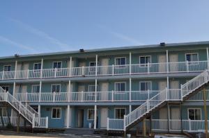 大洋城浪花汽车旅馆的公寓大楼设有白色阳台和楼梯。