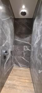 RekkemBnB La Cravache的一间铺有黑色大理石墙的浴室