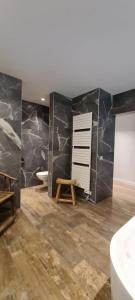 RekkemBnB La Cravache的浴室配有黑色大理石墙壁、浴缸和水槽