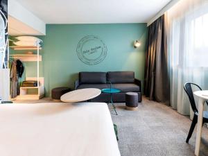 里摩日ibis Styles Limoges Centre的客厅配有沙发和桌子