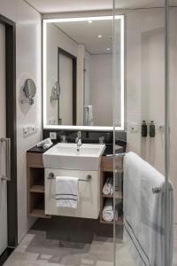 美因河畔法兰克福Meliá Frankfurt City的一间带水槽和镜子的浴室
