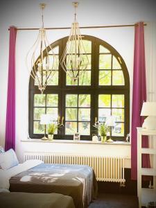 汉堡Sleephotels Suite Garde的一间卧室设有大窗户和紫色窗帘