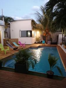 圣路易斯Villa canne à sucre的棕榈树房子后院的游泳池