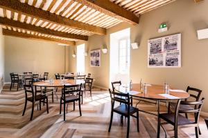 萨路特德沃克吕兹Le Nesk Ventoux - Hotel的用餐室配有木桌和椅子