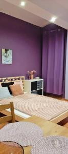 卡托维兹Jopi Hostel Katowice Centrum的一间卧室配有一张紫色墙壁的床