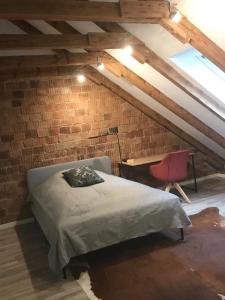 汉诺威Martins Guesthouse Zimmer的砖墙卧室配有床和书桌