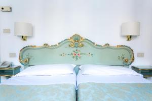 威尼斯瑟瑞尼斯玛酒店的一张带蓝色床头板的床和两个枕头
