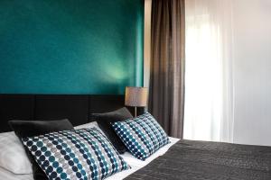 克拉科夫佩拉酒店的一间卧室配有一张带蓝色和白色枕头的床